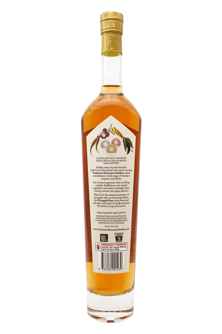 Back of 500ml clear glass bottle of Tamborine Mountain Distillery Pineapple Rum, featuring a watercolour-style illustrated label reflecting its flavour profile.