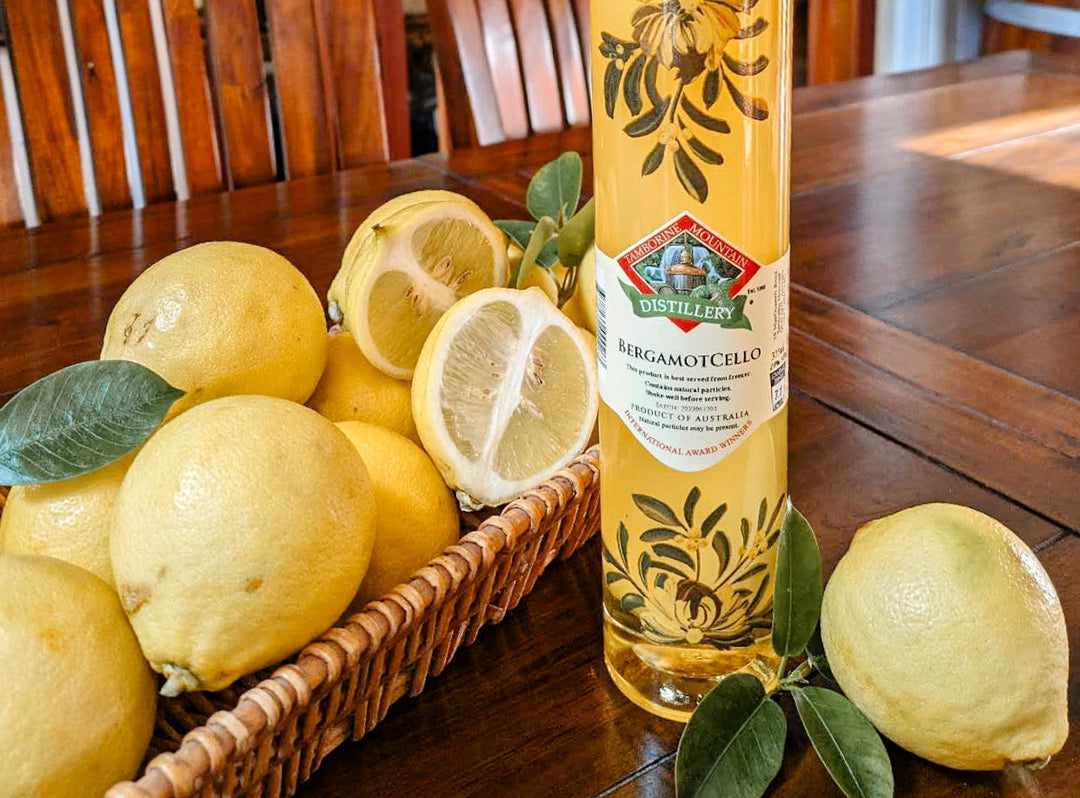 Tamborine Mountain Distillery Bergamotcello on a wooden table with a basket of fresh bergamot fruit.