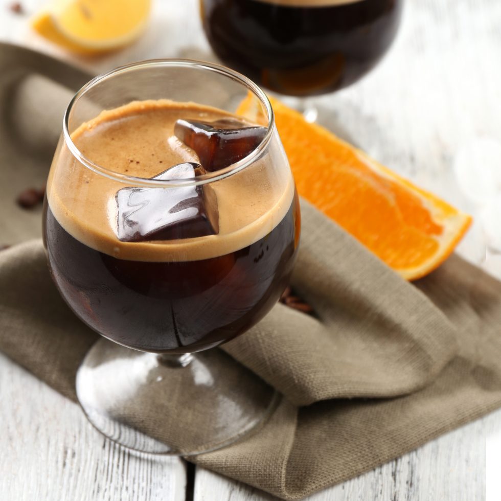 Coffee Blonde cocktail with Gold Rum, Choc 'n' Chilli and Jaffa liqueurs, fresh espresso, and ice in a balloon glass.