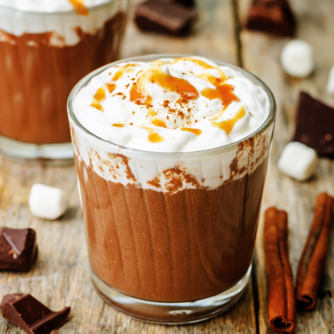 Butterscotch Hot Chocolate made with Butter Whiskey Liqueur, dark chocolate, cocoa, and milk, topped with whipped cream and caramel garnish.