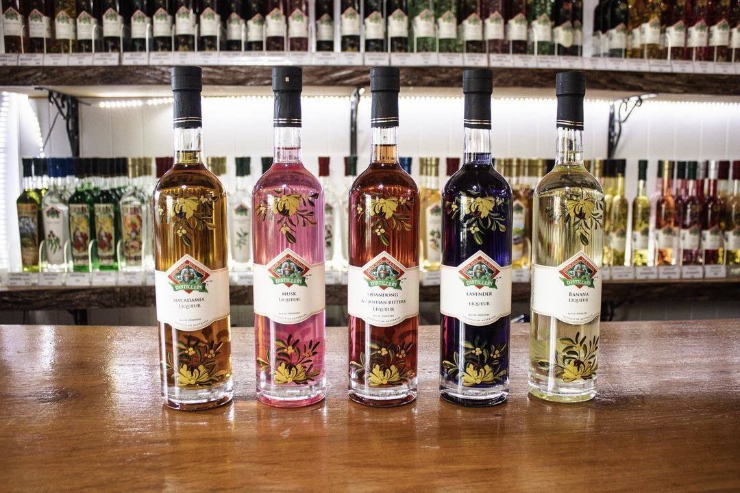 A row of five Tamborine Mountain Distillery larger bottles featuring the signature Ukrainian floral artwork permanently set onto the glass, perfect for sharing or display.