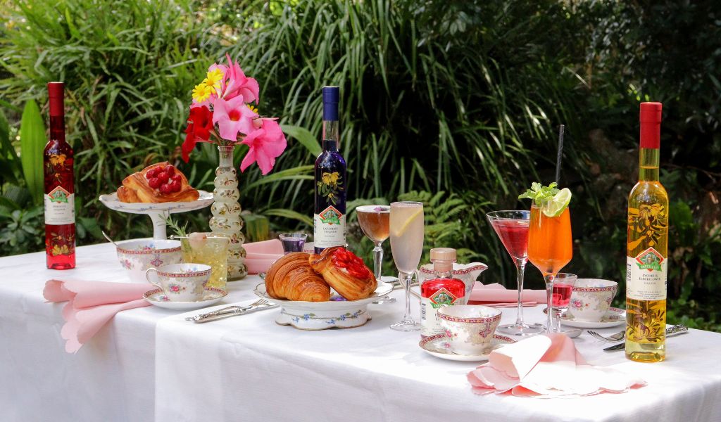 Mother’s Day brunch cocktails including Lavender Sour, Hibiscus Bellini, Violet 75, and Lychee Elderflower Gin and Tonic styled with floral garnishes in elegant glassware