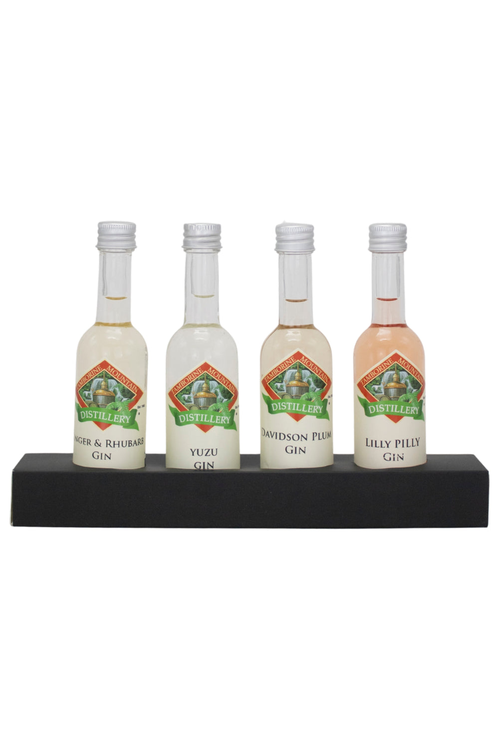 Four miniature gin bottles on a black stand with a white background