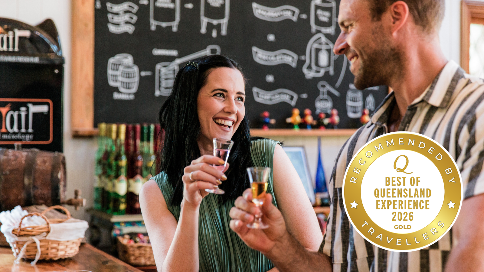 Two people enjoying drinks at Tamborine Mountain Distillery tasting room witha a 'Recommended Gold by Queensland Experience Travellers' badge.