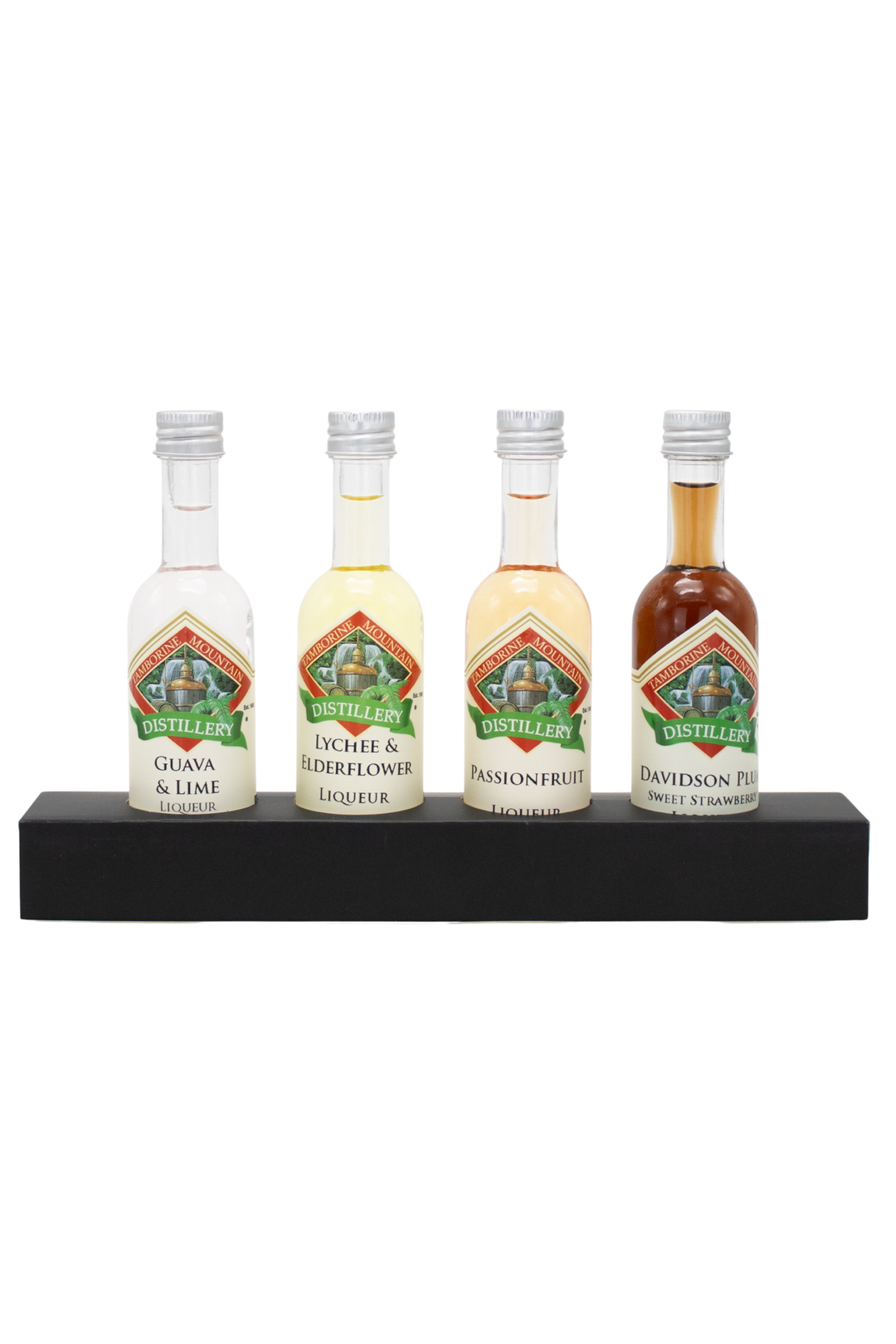 Four miniature distillery spirit bottles displayed on a black rectangular stand against a plain white background. The bottles include Gin & Lime, Liqueur, Passionfruit, and Davidson Fizz.
